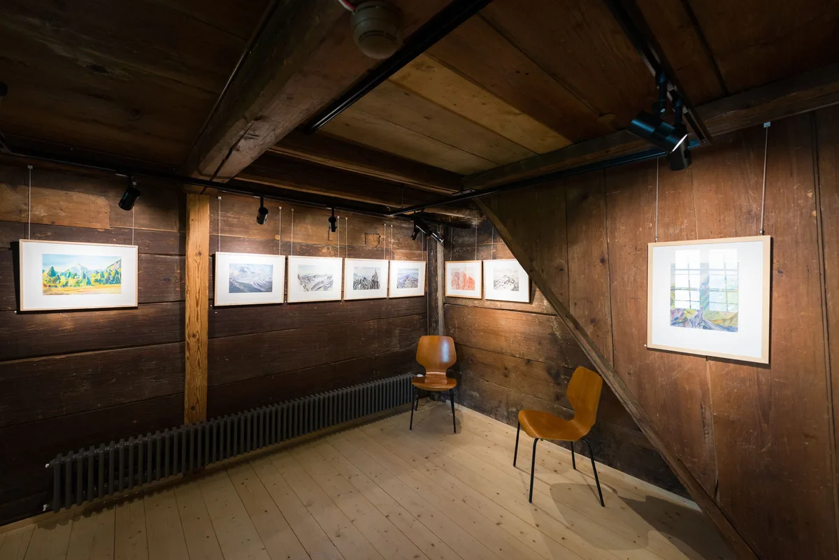 Aufgehängte Bilder in einem alten Raum aus Holz.